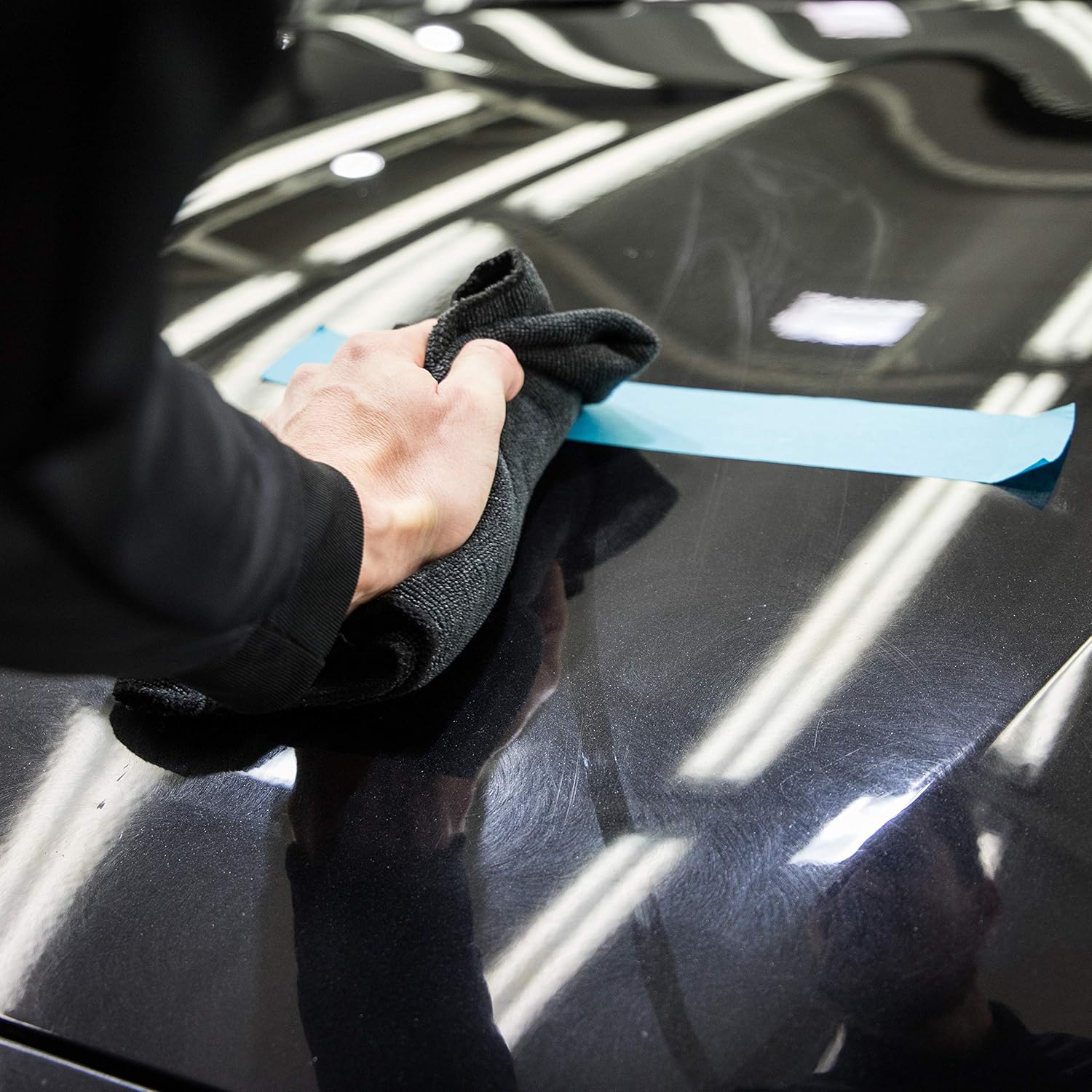 imagem de um especialista em detalier aplicando cera no carro